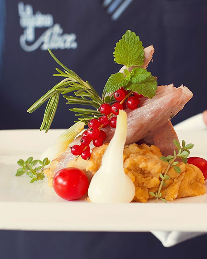Un piatto portato in sala, con il grembiule La Cucina di Alice