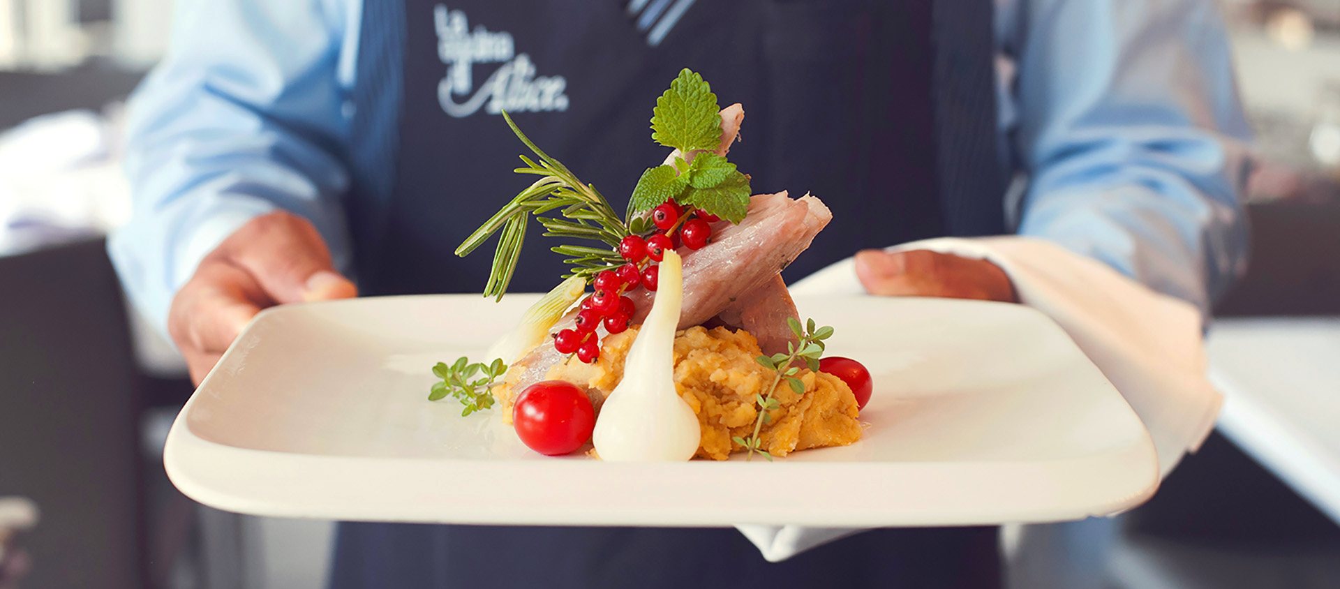 Un piatto portato in sala, con il grembiule La Cucina di Alice